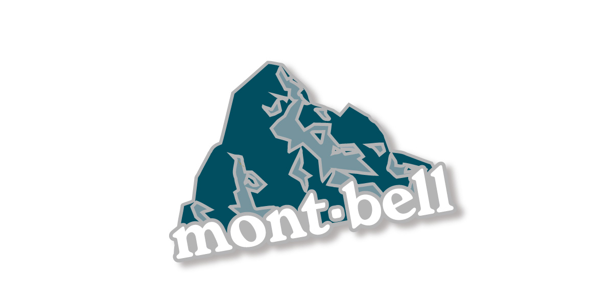 An image of an original pin badge. It is shaped like a mountain and features the Montbell logo.