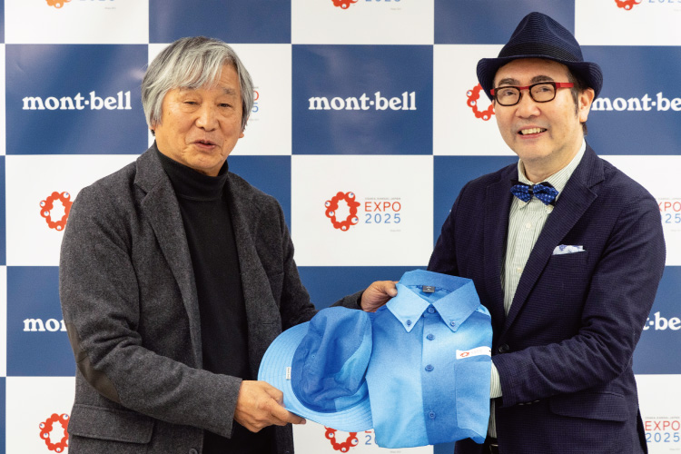 Representative of Montbell, Isamu Tatsuno, holding a uniform with biologist Shinichi Fukuoka.