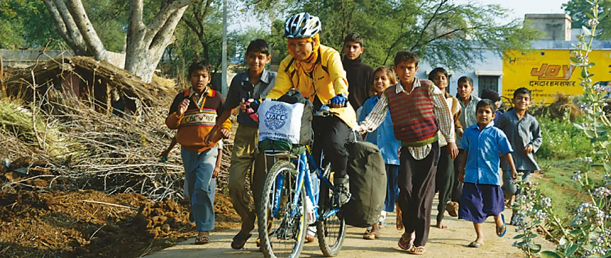 Shiel Emiko, who travels by mountain bike. Many children are walking with their bicycles around.