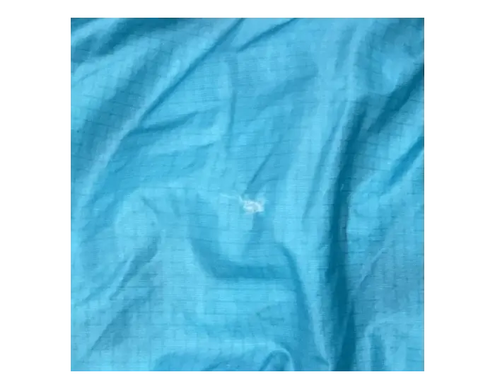 Sleeping bag before repair: Hole and damaged fabric