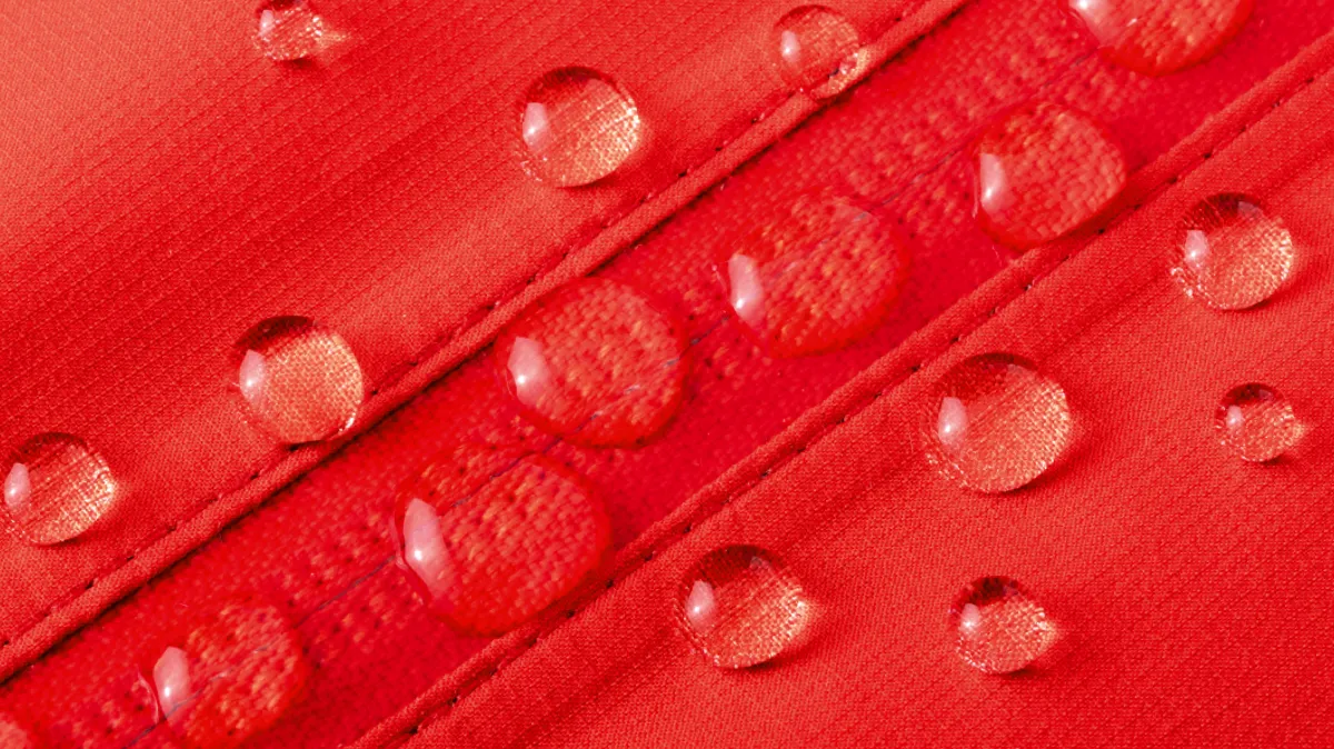 Water droplets beading on a metal zipper, creating a sleek, water-resistant effect