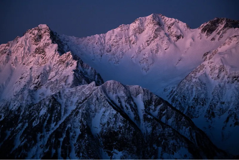 The white Hotaka mountain range is beginning to turn red with the glow of the sunrise.
