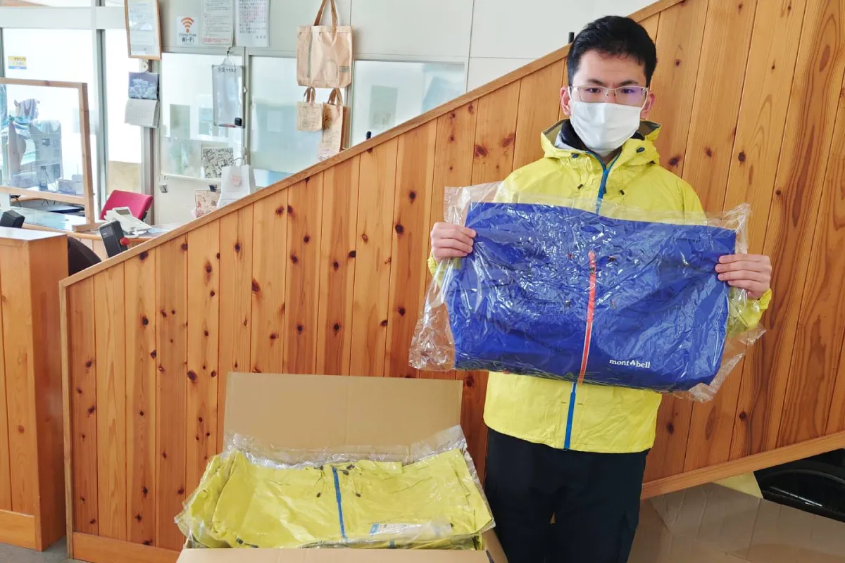 A man receiving a rainwear jacket