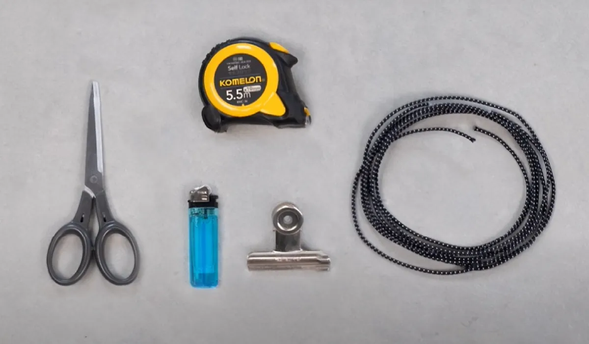 Essential tent items (replacement shock cord, lighter, clips, and measuring tape) are laid out.