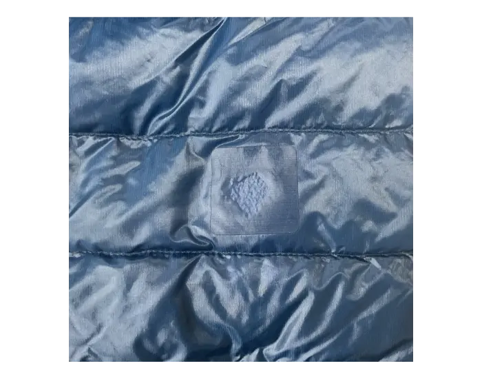 Down jacket after repair: A patch using original fabric is applied.