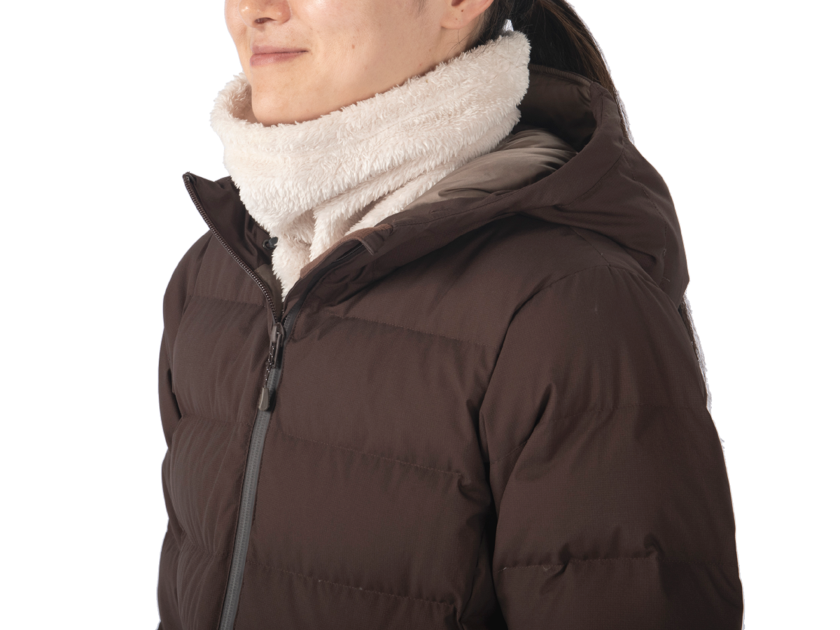 A woman wearing a neck gaiter and down outerwear