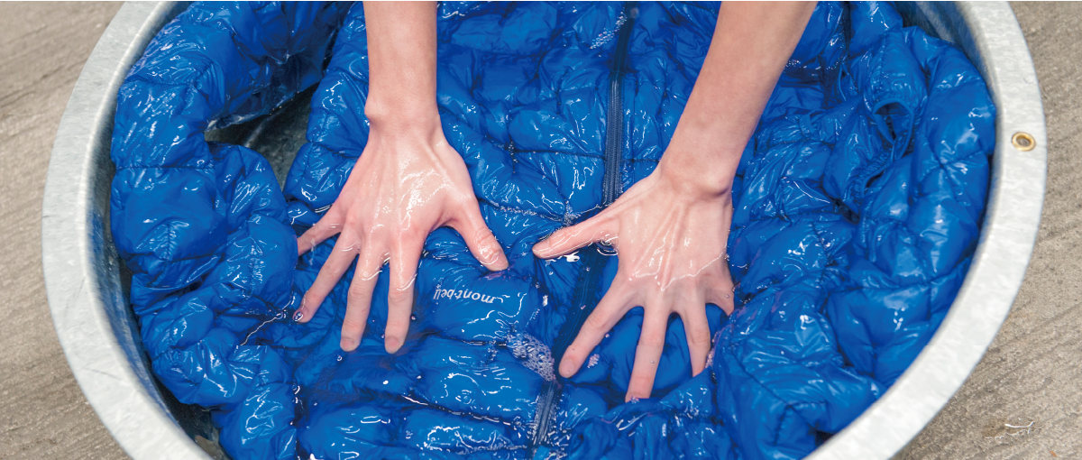 The scene of hand-washing blue down outerwear in a washing basin
