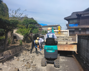 Clearing debris in front of a house.