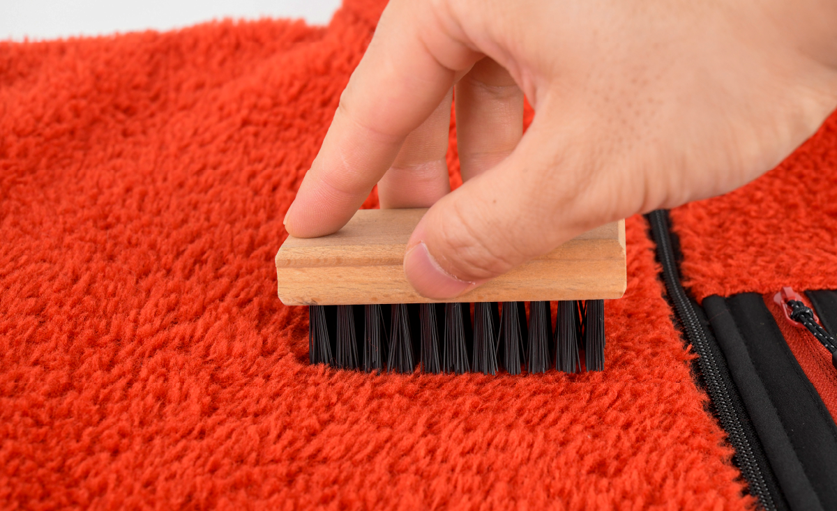 An image depicting the process of brushing the napped surface of fleece fabric
