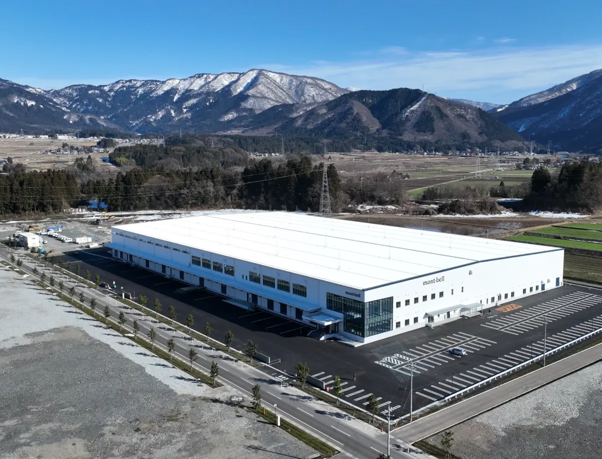 Exterior view of Hokuriku Montbell Co., Ltd.'s Ono Distribution Center. A 2-story building with white exterior walls.