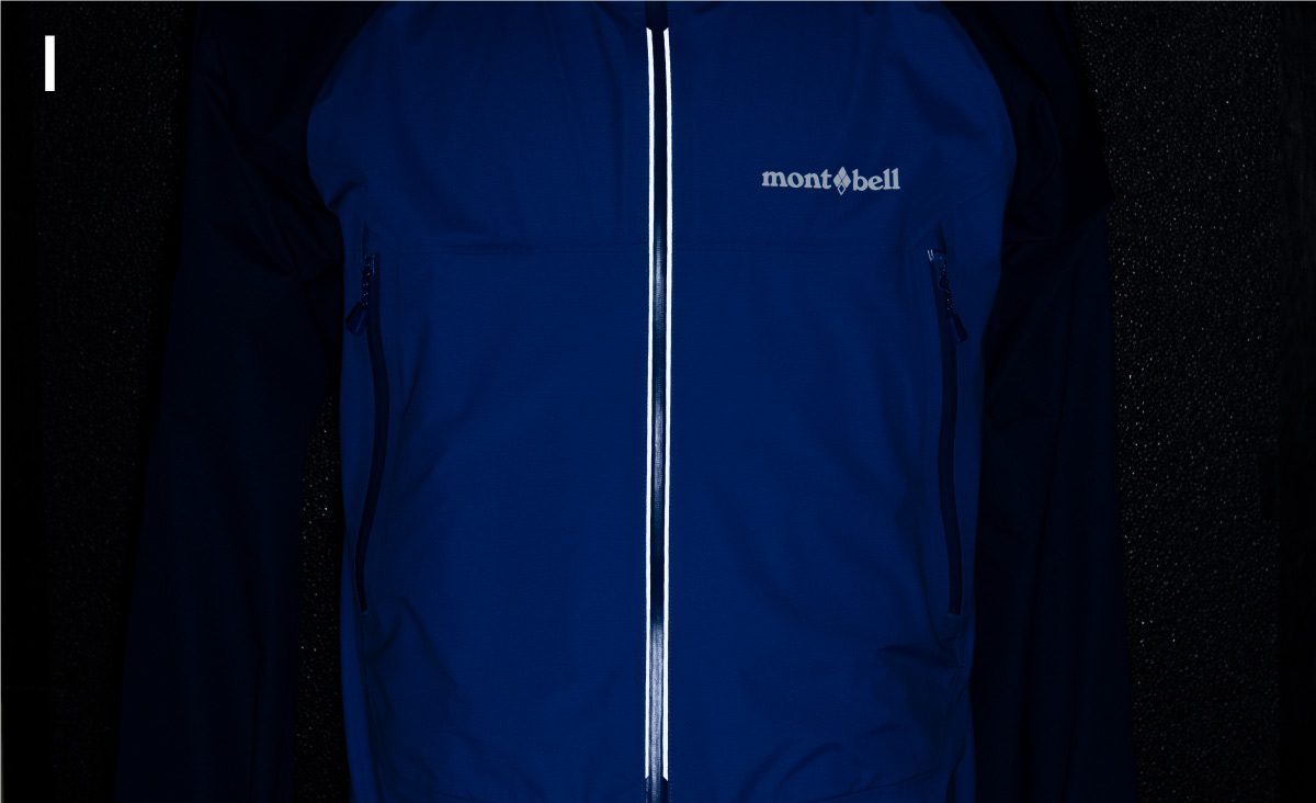 A picture of a jacket with a light shining on it in the dark. The reflective tape is glowing.