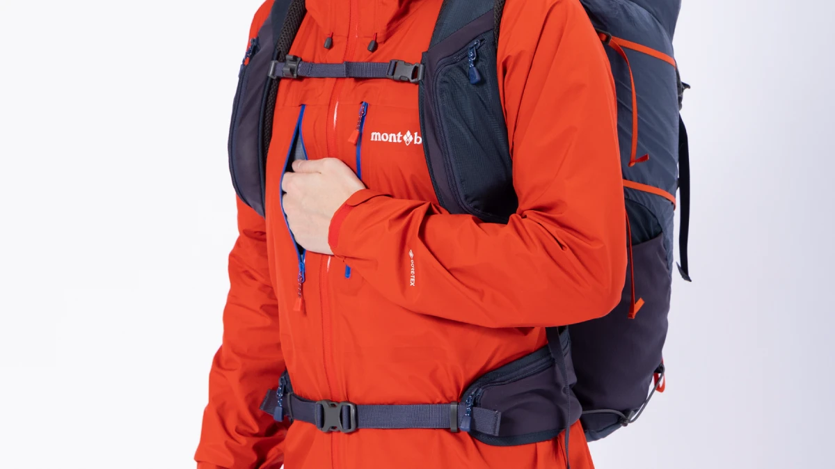 Chest pocket positioned to minimize interference with backpack harness and straps
