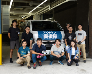 A group photo in front of a vehicle loaded with relief supplies.