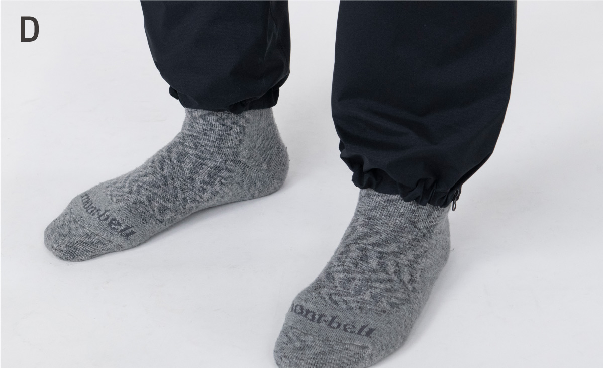 A close-up photo of the feet. It gives the impression that the hems of the pants are cinched with an elastic band.