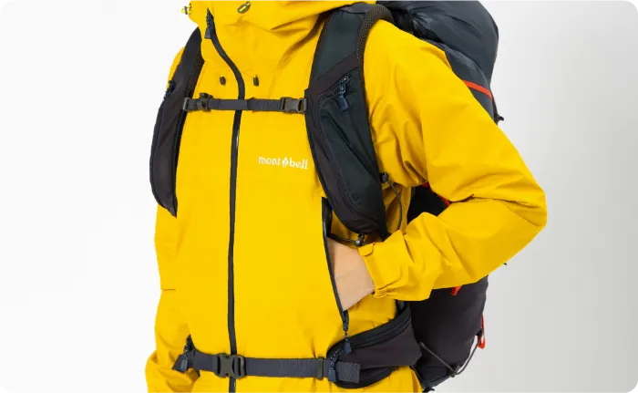 A hand is inserted into the left pocket of the rain jacket.  The explanation follows later.
