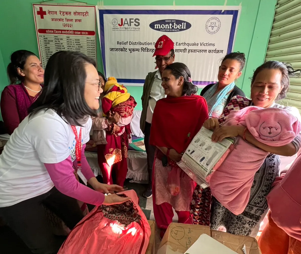 Disaster victims receiving relief supplies such as down jackets and sleeping bags.