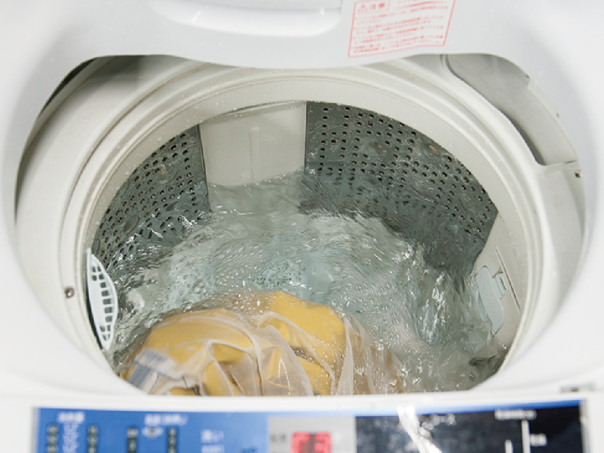 A photo of rinsing rainwear in a laundry net in a washing machine