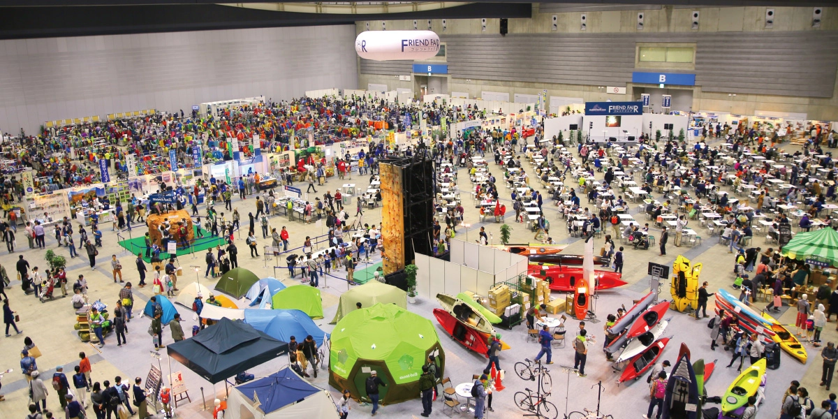A scene from an indoor event. Many people are shopping and participating in experiential activities.