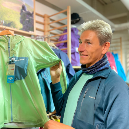 Store staff explaining about a green T-shirt product.