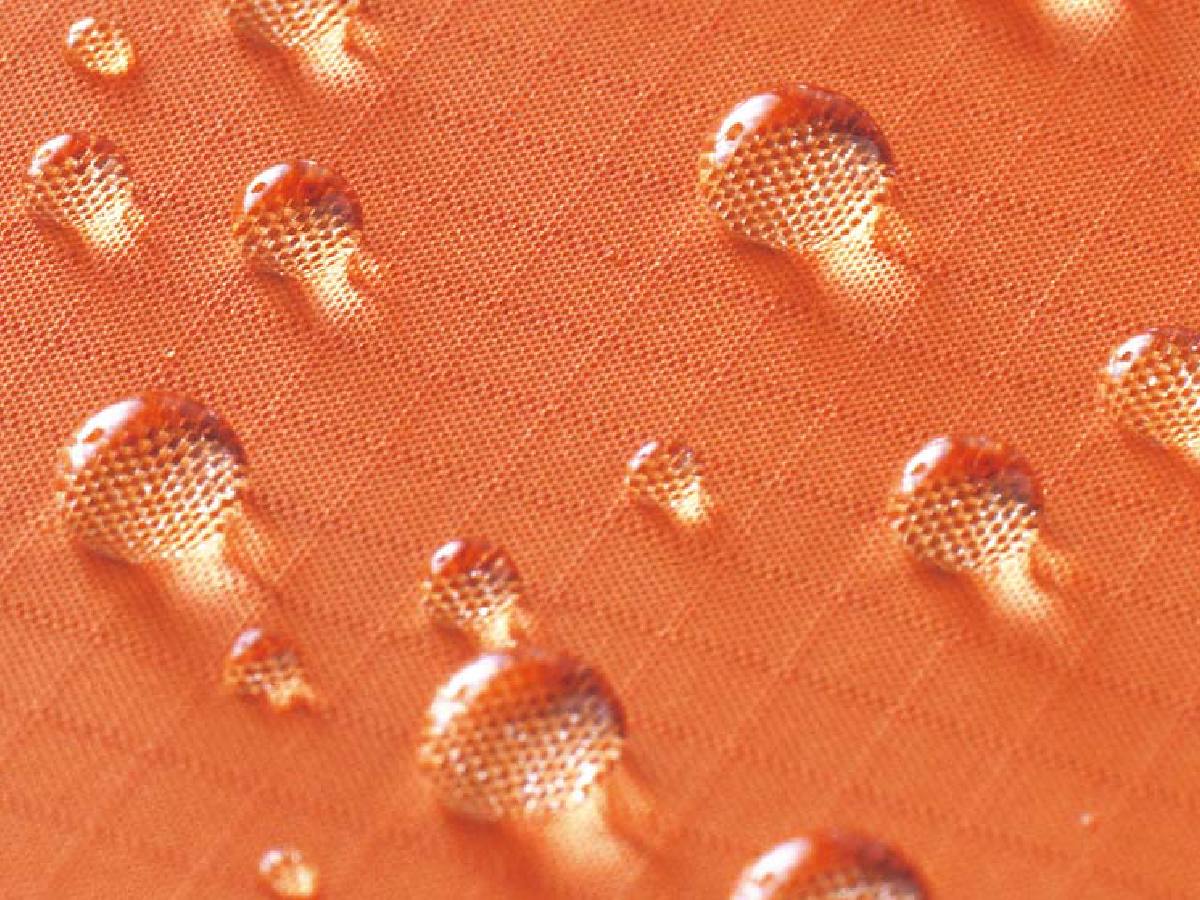 The fabric repels water, with many water droplets sitting on its surface.