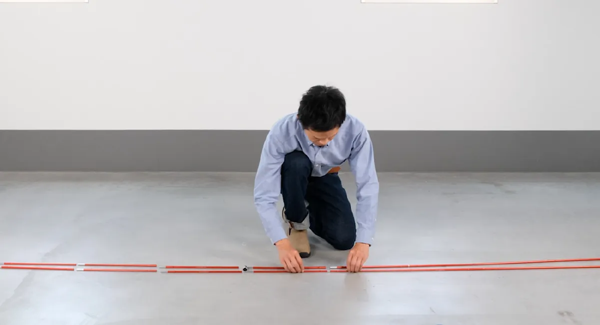 A man is shown arranging poles in sequence after removing the shock cord.