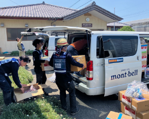 A group of volunteers carrying relief supplies out of a truck.